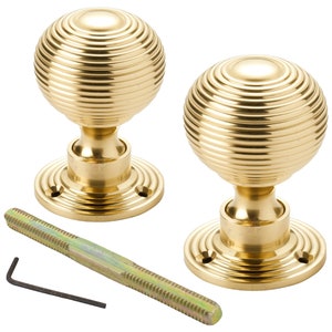 May include: Two brass door knobs with a ribbed, spherical design. Each knob sits on a circular base with screw holes. A threaded rod and an Allen key are included. Suitable for interior doors.
