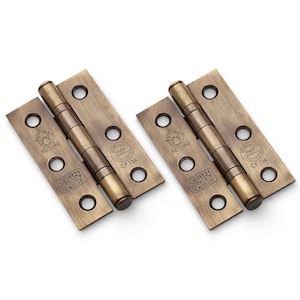 May include: Two antique brass-finished metal door hinges featuring a central barrel and rectangular plates with four screw holes each. The plates are stamped with the text FD30/60, CE 1121, GRADE 7, EN1935, and a circular certification mark CF 734.