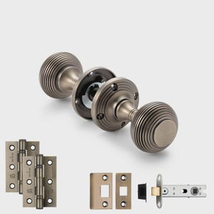 May include: Antique brass door hardware set. Includes two round doorknobs with grooved detailing, a latch, hinges, and strike plates. The doorknobs are approximately 6.35 cm in diameter. The set is designed for interior doors.