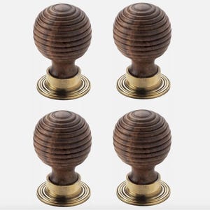 May include: Four wooden door knobs with a spherical design and a dark brown finish. The knobs have a brass base with concentric circles. The knobs are designed for interior doors and cabinets.