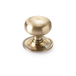 May include: A bronze-coloured door knob with a round, ball-shaped handle. The knob sits on a circular base with a slightly raised edge. The hardware has a vintage or antique appearance.