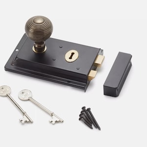 May include: A black door latch with a brass knob and keyhole, alongside two keys and fixings. The latch is rectangular with a matching strike plate. The keys and knob have a silver and brass finish.