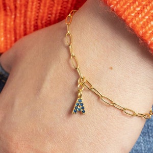 Gold charm bracelet with birthstone initial