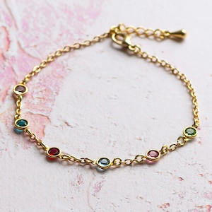 May include: A gold chain bracelet with colourful gemstones. The bracelet has a lobster clasp closure.