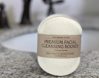 May include: A stack of 12 white organic cotton facial cleansing rounds with a brown paper label that reads "100% Organic Cotton Premium Facial Cleansing Rounds 12 Facial Rounds Small Things To Inspire Big Change www.MicheNiche.com"