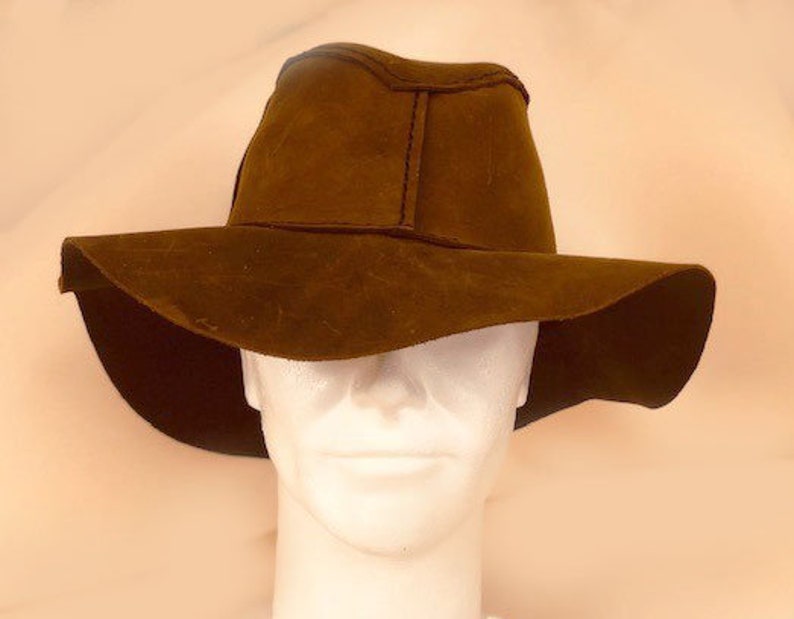Puede incluir: Un sombrero marr&oacute;n de ala ancha con una textura similar al ante. El sombrero se lleva en una cabeza de maniqu&iacute;.