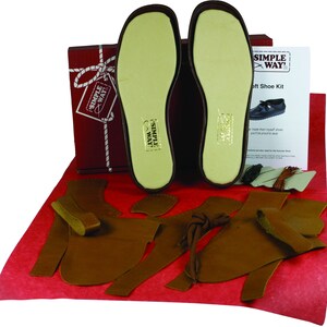 以下が含まれることがあります： 茶色の革の部品、白いインソール1組、そして「Simple Way Soft Shoe Kit」と書かれた赤い箱が入った革靴製作キットです。