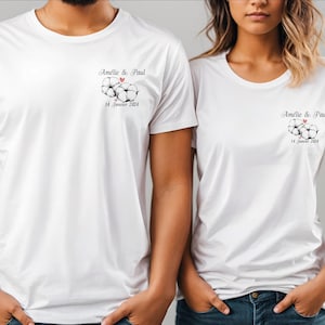 Peut inclure: Deux t-shirts blancs avec un motif de fleur de coton et le texte "Amelie & Paul 14 Janvier 2024" imprimé sur le devant.