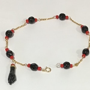 Nieuwe 14k massief gouden azabache dames- (of baby) armband met hangend handje