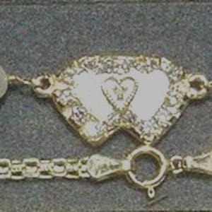 May include: A gold-toned bracelet featuring a central heart-shaped charm with clear stones, flanked by white pearls and textured gold-toned leaf-shaped links. A separate gold-toned chain with a repeating square link pattern is positioned below the bracelet.