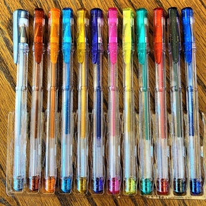 Pu&ograve; includere: Un set di 12 penne in plastica trasparente con inchiostro colorato. Le penne sono disposte in fila e sono tutte della stessa dimensione. I colori dell'inchiostro sono: blu, verde, rosso, arancione, giallo, rosa, viola, nero, argento, oro, marrone e bianco.
