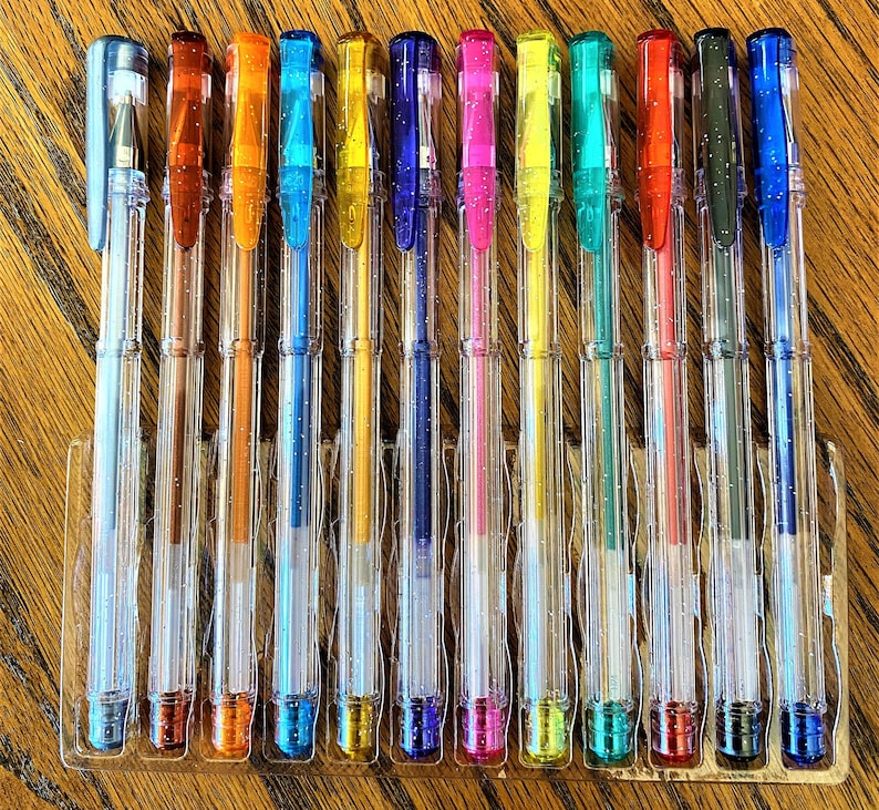 Pu&ograve; includere: Un set di 12 penne in plastica trasparente con inchiostro colorato. Le penne sono disposte in fila e sono tutte della stessa dimensione. I colori dell'inchiostro sono: blu, verde, rosso, arancione, giallo, rosa, viola, nero, argento, oro, marrone e bianco.