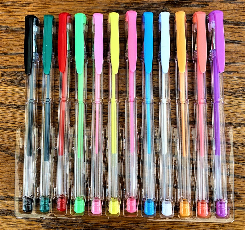 Pu&ograve; includere: Un set di 14 penne gel trasparenti con inchiostro di diversi colori. Le penne sono disposte in fila e sono tutte in un portapenne di plastica trasparente. I colori dell'inchiostro sono nero, verde, rosso, verde lime, rosa, giallo, rosa chiaro, blu, bianco, arancione, arancione chiaro, corallo e viola.