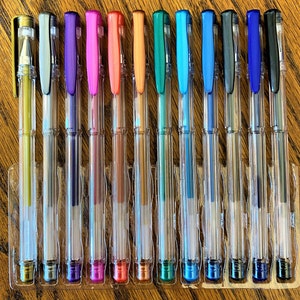 Pu&ograve; includere: Un set di 14 penne in plastica trasparente con inchiostro metallizzato. Le penne sono disposte in fila e presentano una variet&agrave; di colori, tra cui oro, argento, viola, rosa, rosso, arancione, verde, blu e nero.