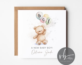 May include: A new baby boy card featuring a watercolour illustration of a teddy bear holding balloons that spell out "BOY". The card reads "A new baby boy! Oliver Jude".