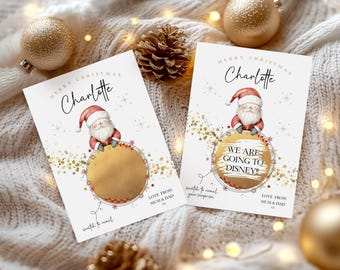 May include: Two Christmas scratch-off cards featuring a Santa Claus illustration. The cards have gold detailing and the text "Merry Christmas Charlotte". One card reveals "We are going to Disney!" after scratching. The cards are surrounded by gold baubles.