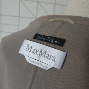 Op de afbeelding: Een bruine Max Mara blazer met een wit label waarop "Max Mara" en "Made in Italy" staat. Het label heeft ook een kleiner zwart label met de tekst "Cucito a Mano".