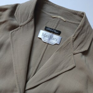 Op de afbeelding: Een beige blazer met een Max Mara-label met de tekst "Ciuccio a Mano" en "Made in Italy".