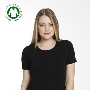 May include: A black short-sleeved t-shirt with a round neckline. The t-shirt is made of organic cotton and has the Global Organic Textile Standard (GOTS) certification logo.