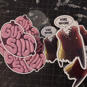 May include: Four pink brain-shaped stickers with the text "GUTS SLUT" and three red dragon stickers with the text "VORE WHORE".