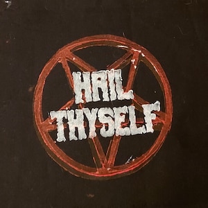 K&ouml;nnte beinhalten: Ein schwarzer Patch mit einem roten Pentagramm und den Worten "Hail Thyself" in wei&szlig;en Buchstaben.
