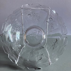 May include: A clear glass plate with an etched design of oak leaves and acorns. The plate has a scalloped edge and a raised centre.