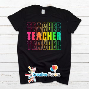 May include: Black t-shirt with the word "TEACHER" repeated in rainbow colors.