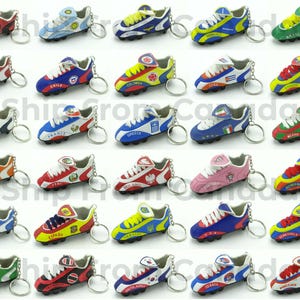 May include: A collection of miniature soccer shoe keychains, each featuring a different country's flag design. The shoes are in various colors, including red, blue, green, and yellow, with silver key rings attached. These decorative keychains are a fun accessory for sports fans.
