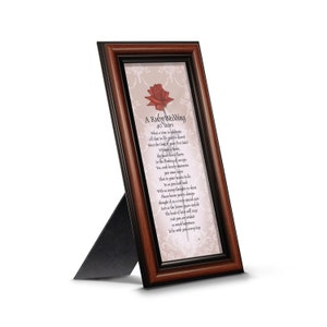 May include: A framed poem about a ruby wedding anniversary, with a red rose illustration. The poem reads "A Ruby Wedding 40 Years What a time to celebrate All that in life you've shared Since the time of your first hand Without a doubt, a lady In the heart of a flower, You've been blooming an eye- For the years which have gone, You've surely learned to be So much love you have That in your heartbeat to lie So many thoughts to share Widly know you're a treasure Please know every special date Thought of as a very dear And as the future years unfold The bond of love will carry So much happiness To be with you every day."
