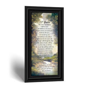 May include: A framed vertical wall art piece featuring the text of the 23rd Psalm printed over a landscape illustration of a lush green valley with trees, a stream, and small sheep, all enclosed within a decorative black rectangular frame.