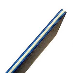 May include: Close-up of the edge of a black nail file with blue and white stripes.
