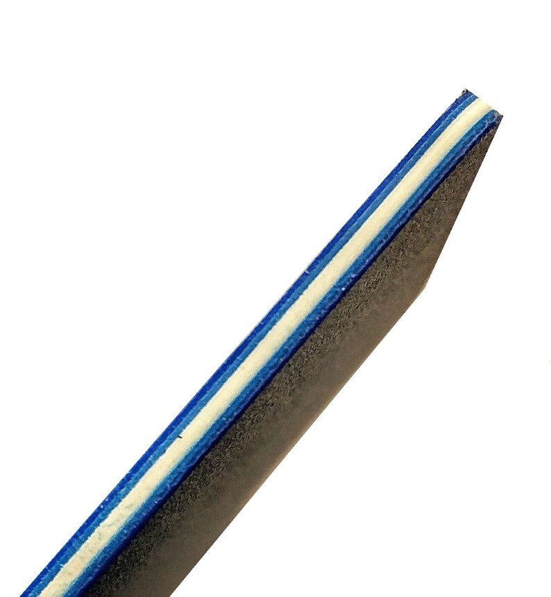 May include: Close-up of the edge of a black nail file with blue and white stripes.