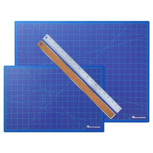 May include: Two blue self-healing cutting mats with a silver ruler on top. The mats are marked with a grid pattern and have the text "The Art Institutes" printed on them.