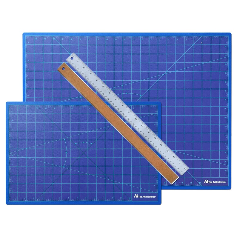 May include: Two blue self-healing cutting mats with a silver ruler on top. The mats are marked with a grid pattern and have the text "The Art Institutes" printed on them.