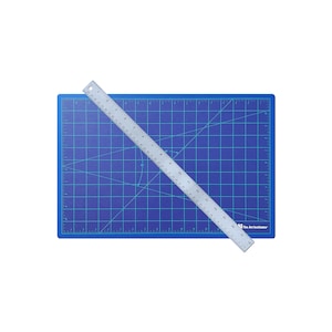 May include: A blue self-healing cutting mat with a silver ruler on top. The ruler is marked in inches and has the text "The Art Institute" printed on it.