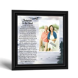 May include: A black framed wall art piece featuring the Footprints in the Sand poem printed on a beach background with a seagull. A rectangular window on the right side is designed to hold a 4x6 inch photo, currently displaying a placeholder image.