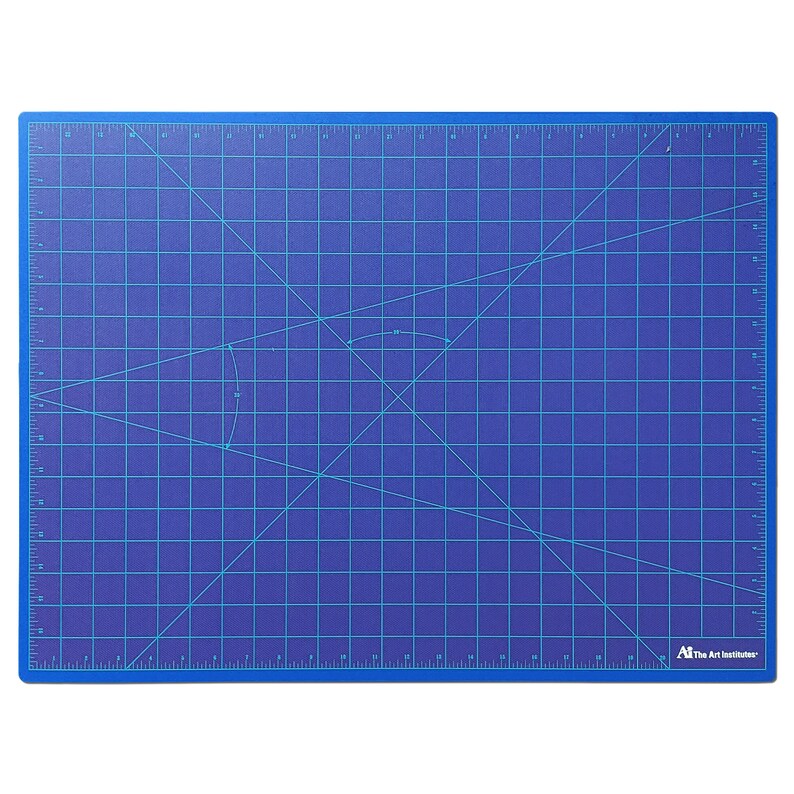 May include: A blue self-healing cutting mat with a grid pattern and diagonal lines. The mat has inch measurements along the edges and a "The Art Institutes" logo in the bottom right corner.