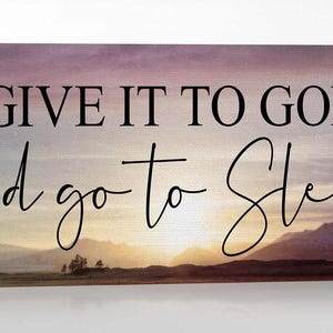 May include: A canvas print with a purple and pink sunset background. The text "GIVE IT TO GOD and go to sleep" is written in black.