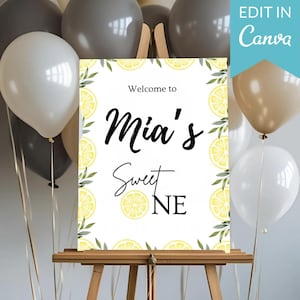 Könnte beinhalten: Ein weißes Schild auf einer Holzstaffelei mit dem Text "Welcome to Mia's Sweet ONE". Das Schild ist mit Zitronenscheiben und grünen Blättern verziert. Ballons in Weiß, Grau und Beige sind im Hintergrund. Der Text "Edit in Canva" befindet sich oben rechts.