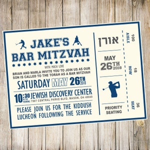 May include: A cream-colored invitation with blue text for a Bar Mitzvah. The invitation is designed to look like a ticket with the text "Jake's Bar Mitzvah" at the top. The date of the event is May 26th, 2018. The event will be held at the Jewish Discovery Center at 10:30 AM. The invitation also includes the address of the center.