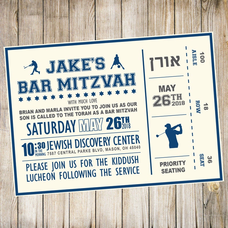 May include: A cream-colored invitation with blue text for a Bar Mitzvah. The invitation is designed to look like a ticket with the text "Jake's Bar Mitzvah" at the top. The date of the event is May 26th, 2018. The event will be held at the Jewish Discovery Center at 10:30 AM. The invitation also includes the address of the center.