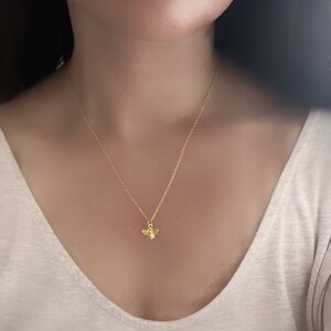 May include: A gold chain necklace with a small bee pendant.