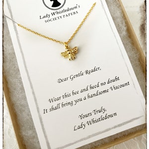May include: A gold bee charm necklace in a small box with a note that reads "Lady Whistledown's Society Papers. Dear Gentle Reader, Wear this bee and heed no doubt It shall bring you a handsome Viscount Yours Truly, Lady Whistledown"