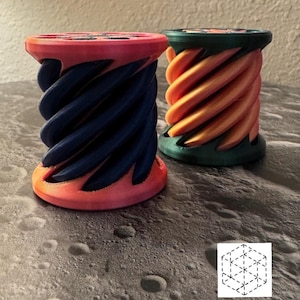 May include: Two 3D printed, spiral-shaped objects. One is orange and green, the other is pink and blue.