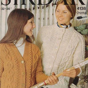 May include: Vintage Sirdar knitting pattern cover featuring two women wearing knitted cardigans. One cardigan is mustard yellow, the other is cream. The text "SIRDAR" is at the top, with "32-36" and "4138 Chunky" below.