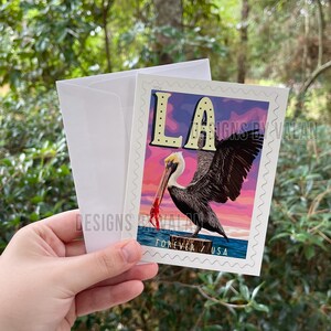 Biglietto d'auguri ispirato al francobollo della Louisiana con pellicano che tiene gamberi e sfondo tramonto