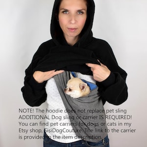 May include: A woman wearing a black hoodie with a gray and blue dog sling inside. The text on the image reads: "NOTE! The hoodie does not replace pet sling ADDITIONAL Dog sling or carrier IS REQUIRED! You can find pet carriers for dogs or cats in my Etsy shop, SisiDogCouture. The link to the carrier is provided in the item description."