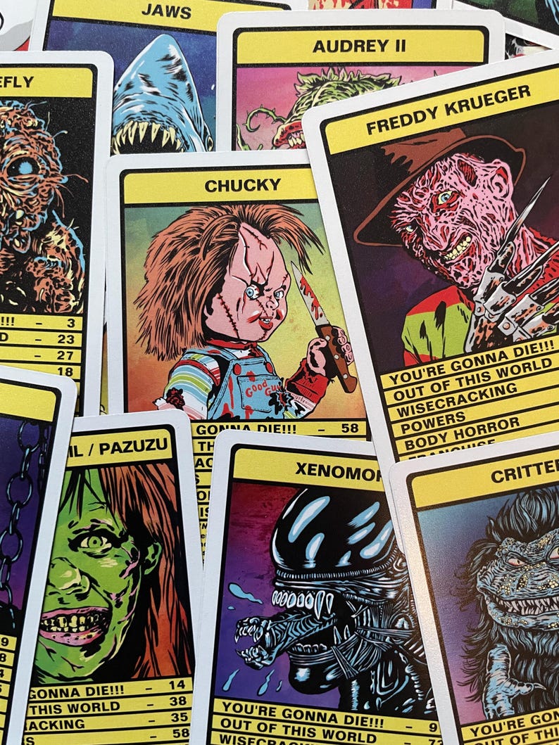 May include: A set of trading cards featuring various horror movie characters, including Chucky, Freddy Krueger, and the Xenomorph. Each card has a colourful illustration of the character and includes text about their powers and abilities. The cards are printed on a white background with black borders.