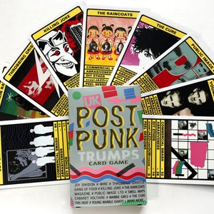 以下が含まれることがあります： カラフルなデザインの「UK Post Punk Trumps」というトランプ。カードには、ジョイ・ディヴィジョン、ワイヤー、スロビング・グリズリー、キリング・ジョーク、ザ・レインコート、ザ・キュアー、パブリック・イメージ・リミテッド、ヤング・マーブル・ジャイアンツなど、さまざまなイギリスのポストパンクバンドの画像が描かれています。