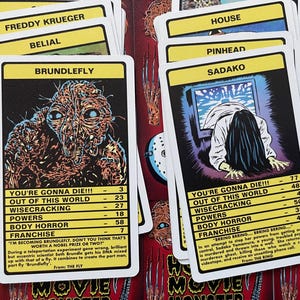 May include: A set of yellow and black playing cards featuring illustrations of horror movie characters. The cards include characters like Freddy Krueger, Belial, Brundlefly, Pinhead, Sadako, and House. Each card has a character name, a "You're Gonna Die!!!" section with stats, and a "Franchise" section with a quote and the movie title.